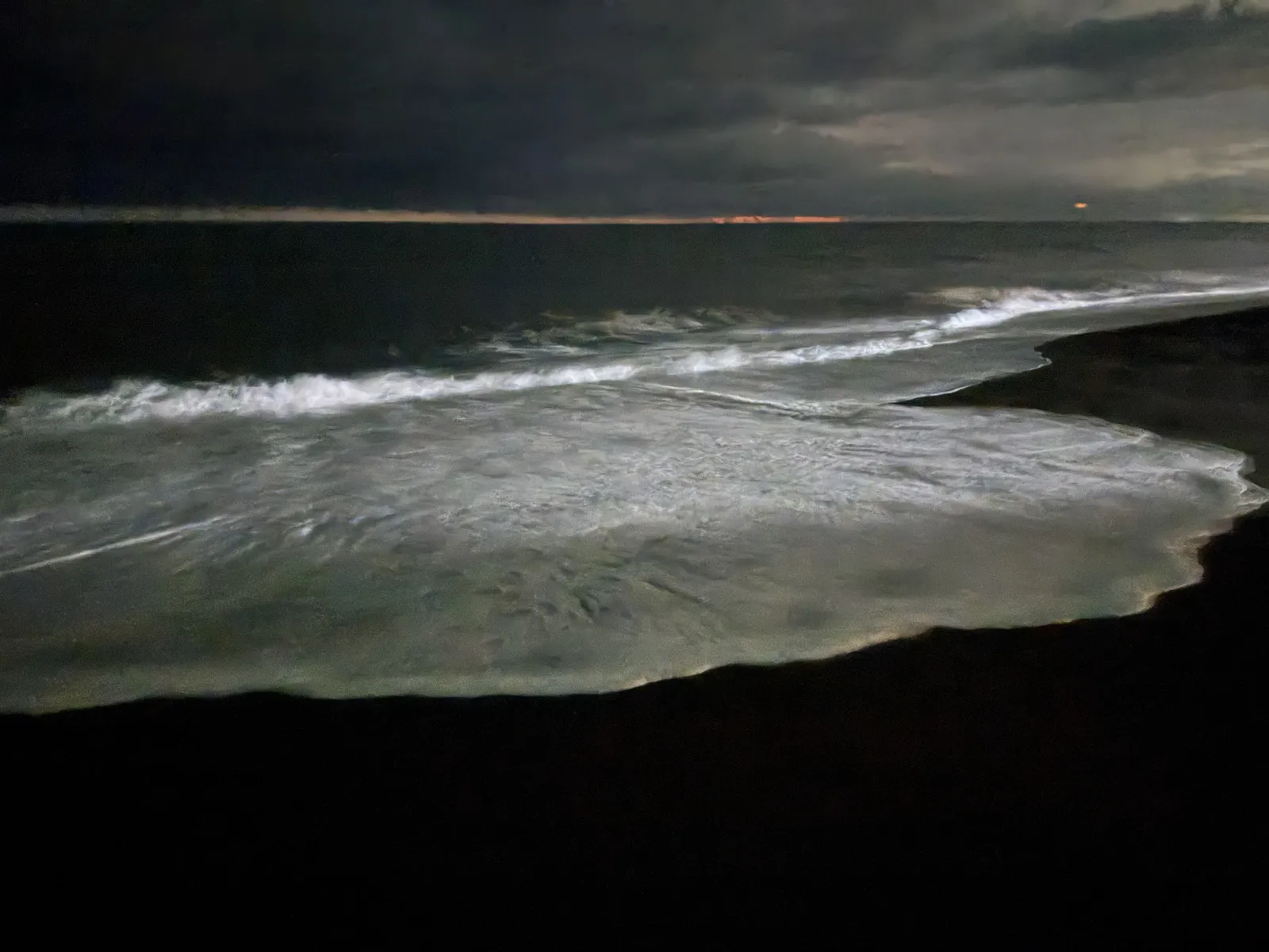 First night on the Pacific side: black sand and white surf.