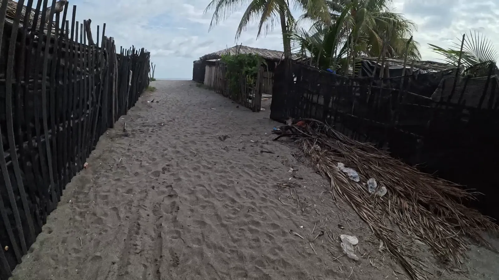 The cut through the fences. Palapas on the right, Pacific straight ahead.