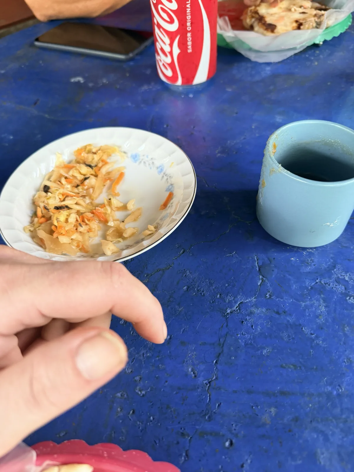 The blue table. Curtido in the good china; salsa in the mug.