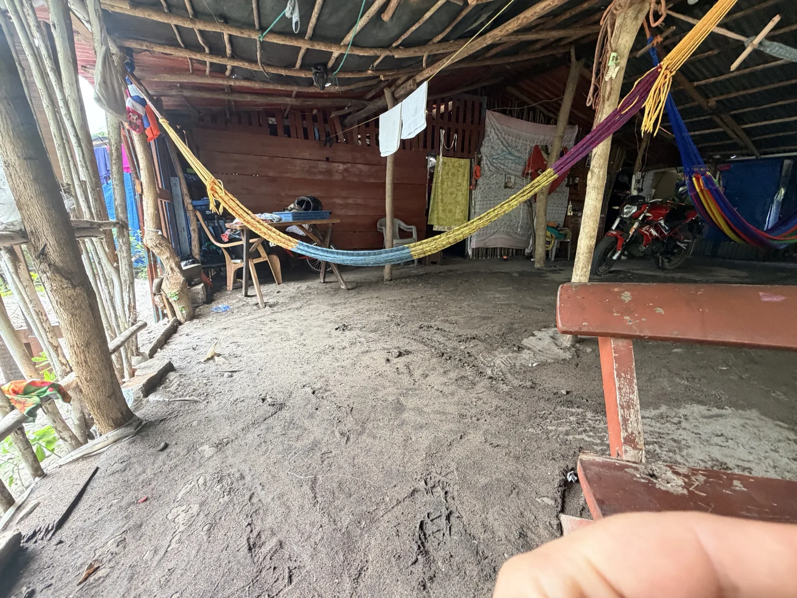Grandma's: tin roof on cut poles, hammocks, the shop at the back, the motorbike in the shade.